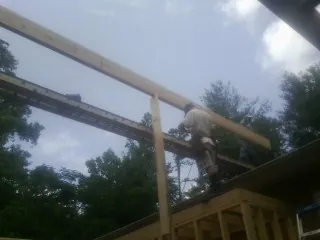 Carpenter setting a ridge beam over a new addition frame — Ice Dam Removal by Roofing Brothers in White Rock